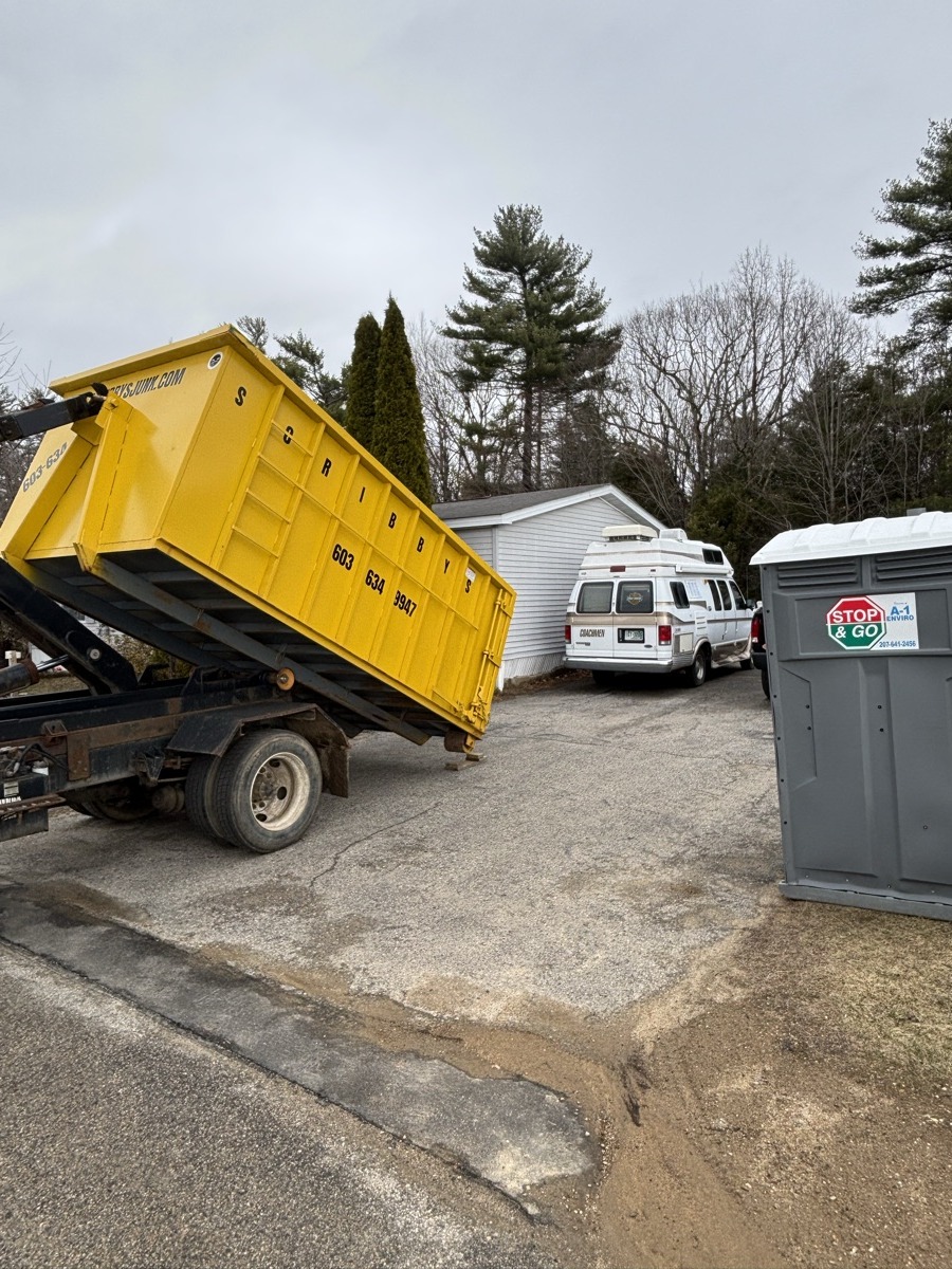 Scribby's roll-off dumpster, STOP & GO porta-john, and branded white truck staged on a driveway for an active remodel jobsite.